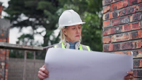 construction engineer reviewing blueprint at construction site