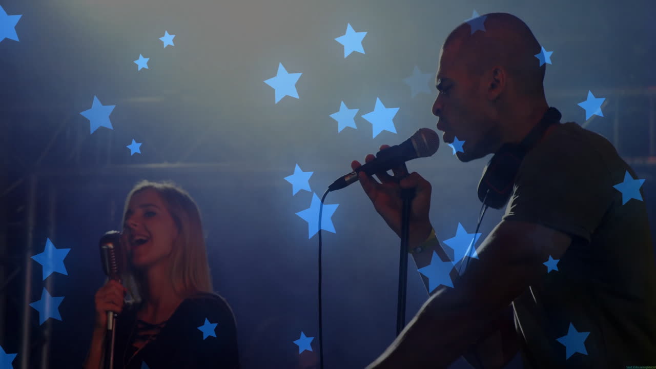 music duo singers performing on concert stage, projecting blue stars and showing wired mic