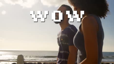 Animation-of-wow-text-over-african-american-couple-at-beach