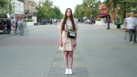 mujer con vestido beige en la calle de la ciudad