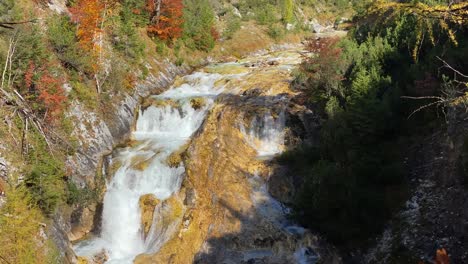 increíble paisaje colorido con cascada en el sendero karwendelsteg en las cercanías de scharnitz en austria con árboles de hoja caduca, tiro inclinado de cerca