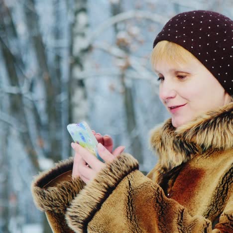 Woman-Uses-Smartphone-In-Winter-Scene-01
