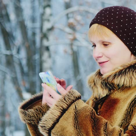 woman uses smartphone in winter scene 01