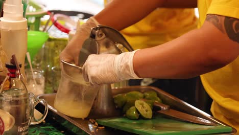 persona exprimiendo limas para hacer jugo