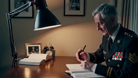 military officer writing at a desk under lamp light