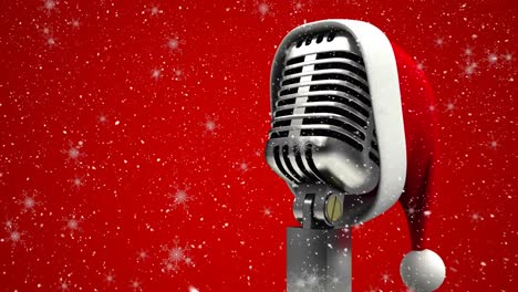 animation of santa's hat on retro microphone over snow falling on red background