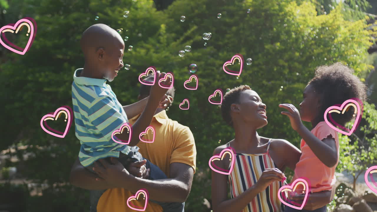 Animatie van harten boven een blije Afro-Amerikaanse familie die zeepbellen maakt in de tuin.