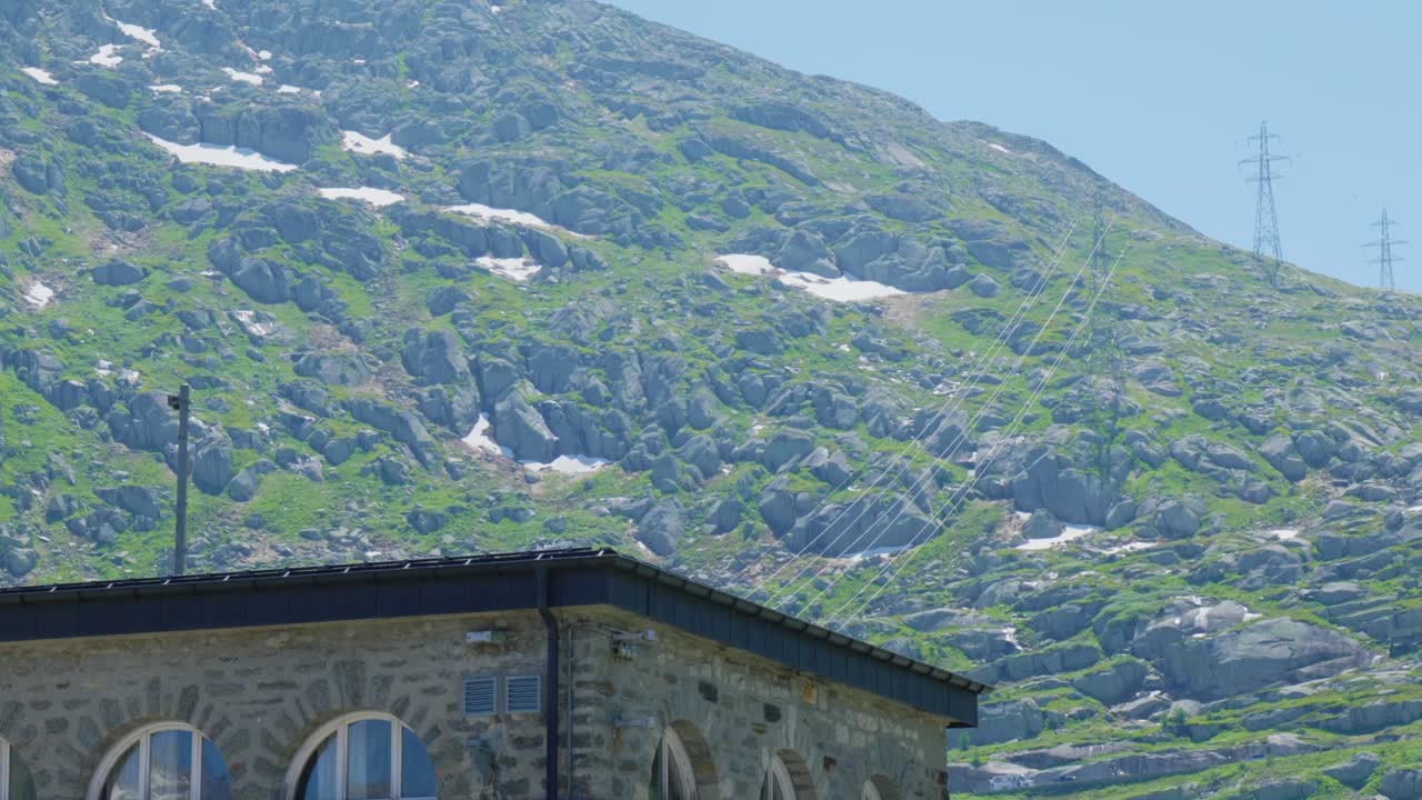 파란 하늘이 있는  ⁇ 은 날에 스위스 알프스 산맥에 있는 빌딩과 파일론