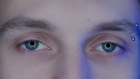 close-up of a person's face with eyebrow piercing