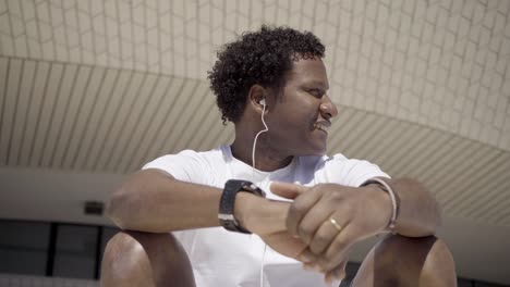 bottom view of smiling african american man listening music