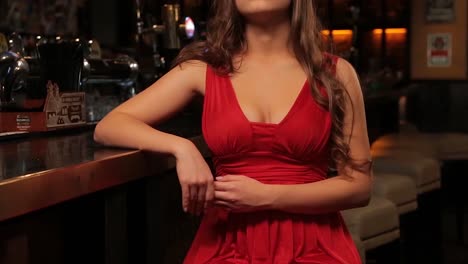 una mujer con un vestido rojo en un bar.