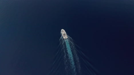birds eye aerial view on isolated motor boat sailing on deep blue water of tropical sea