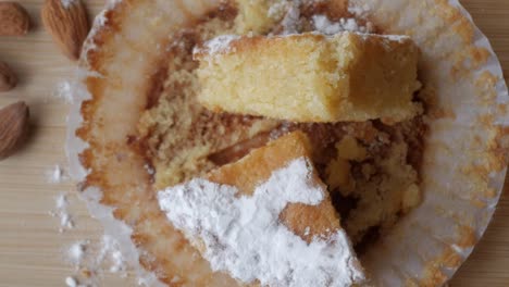 almond cake slice with powdered sugar on a wooden table, rustic feel