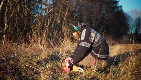 a man is examining his chainsaw - static shot