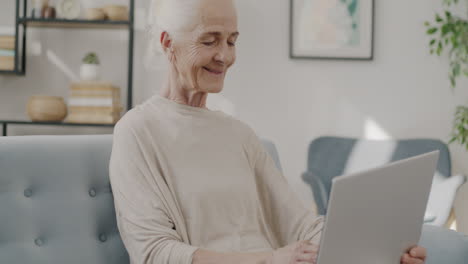 mujer mayor usando una computadora portátil en casa