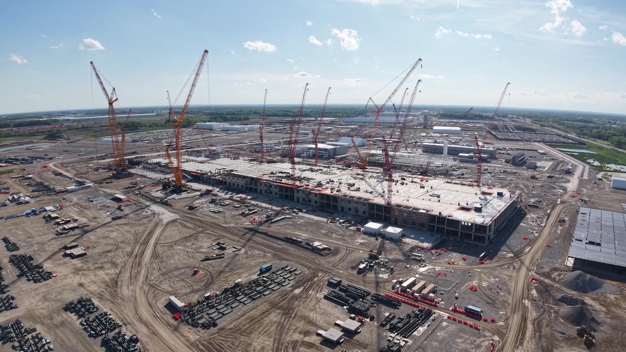 Ampio panorama con drone di gru e fondamenta di edifici in una vasta zona di costruzione industriale