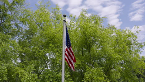 Umlaufbahn-Mit-Niedrigem-Winkel-Um-Die-US-Flagge,-Die-In-Zeitlupe-Weht