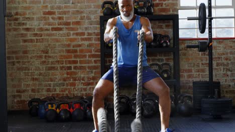 hombre mayor haciendo entrenamiento de cuerda crossfit en el estudio de fitness 4k