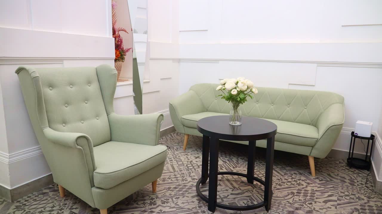 Hotel lobby with green chairs, sofa, and round table