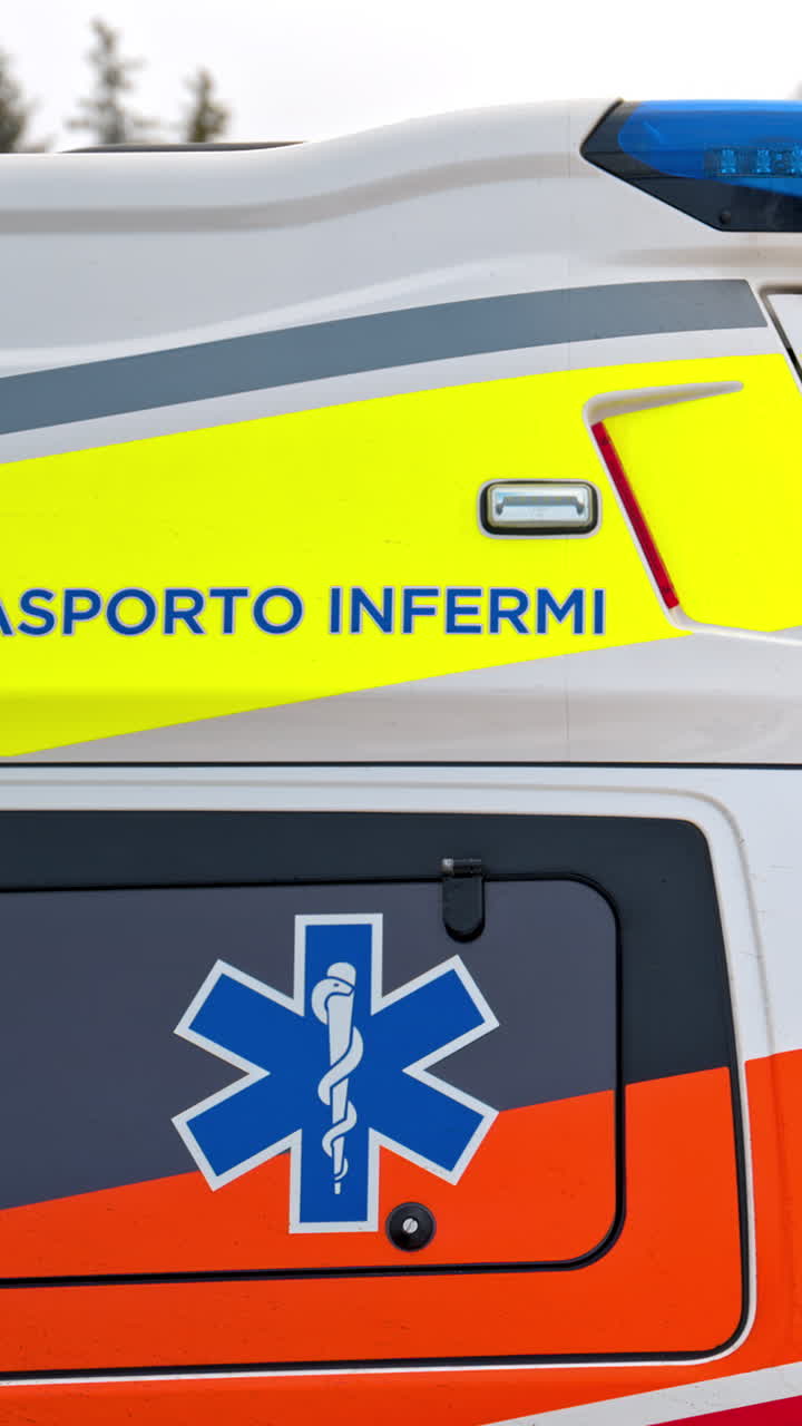 Close up of an ambulance in front of a cabin at a ski resort in the Dolomites, Italy. Vertical