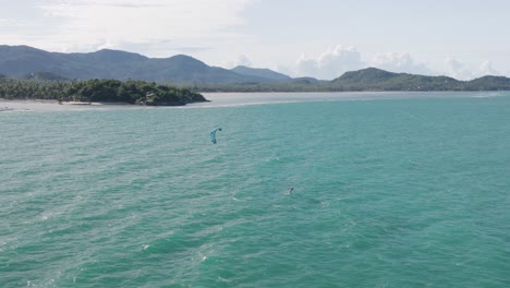 Aerial-of-kitesurfer-on-hydrofoil-cruising-along-shore-of-Koh-Phangan