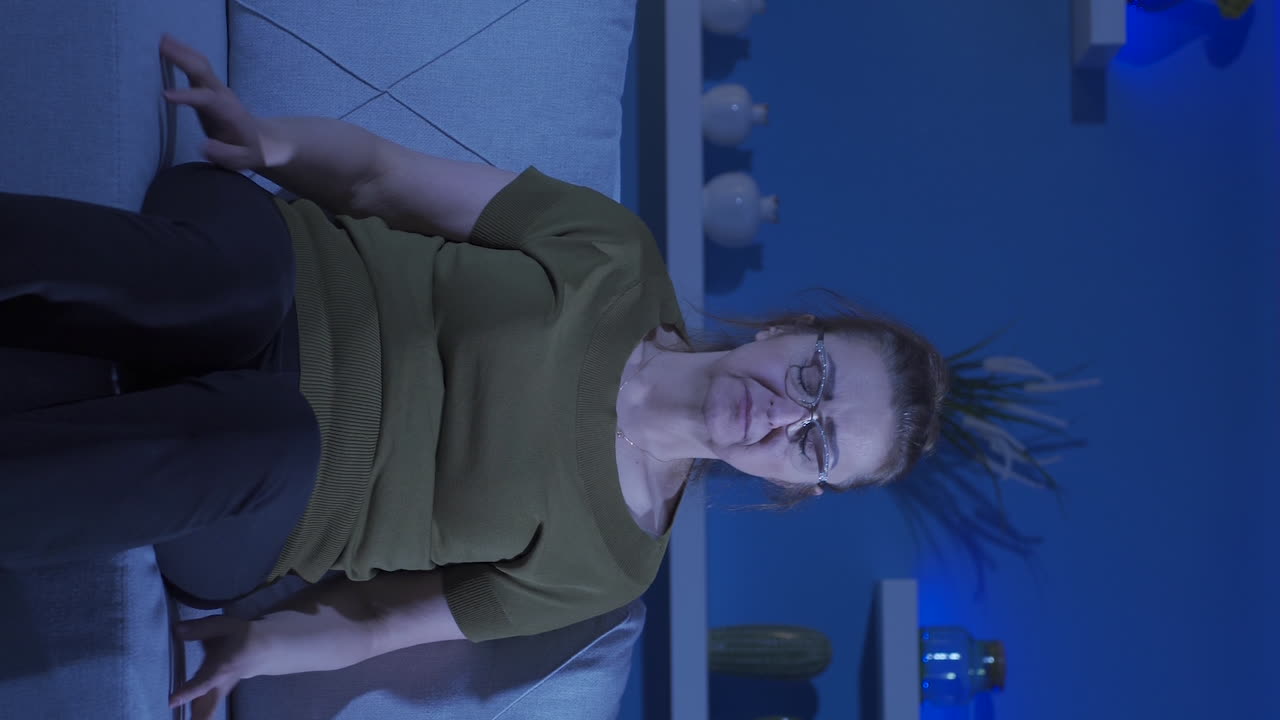 vídeo vertical de la mujer que presiona las almohadas en su cabeza con miedo.