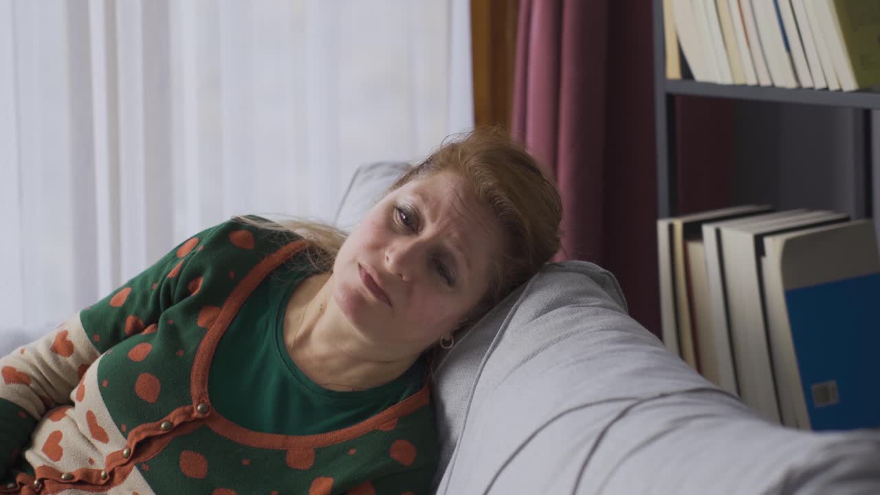 una mujer vieja, triste, miserable y madura llora, decepcionada.