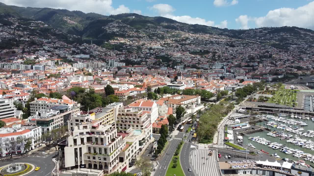 Drone aerial view of a coastal city with buildings along the shoreline. Scenic view perfect for travel, urban, and seaside content