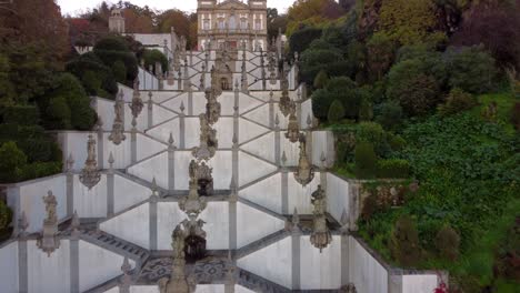 drone vuela sobre el santuario de la catedral cristiana de jesus do monte en el bosque arbolado de la ciudad de braga en portugal durante la puesta de sol