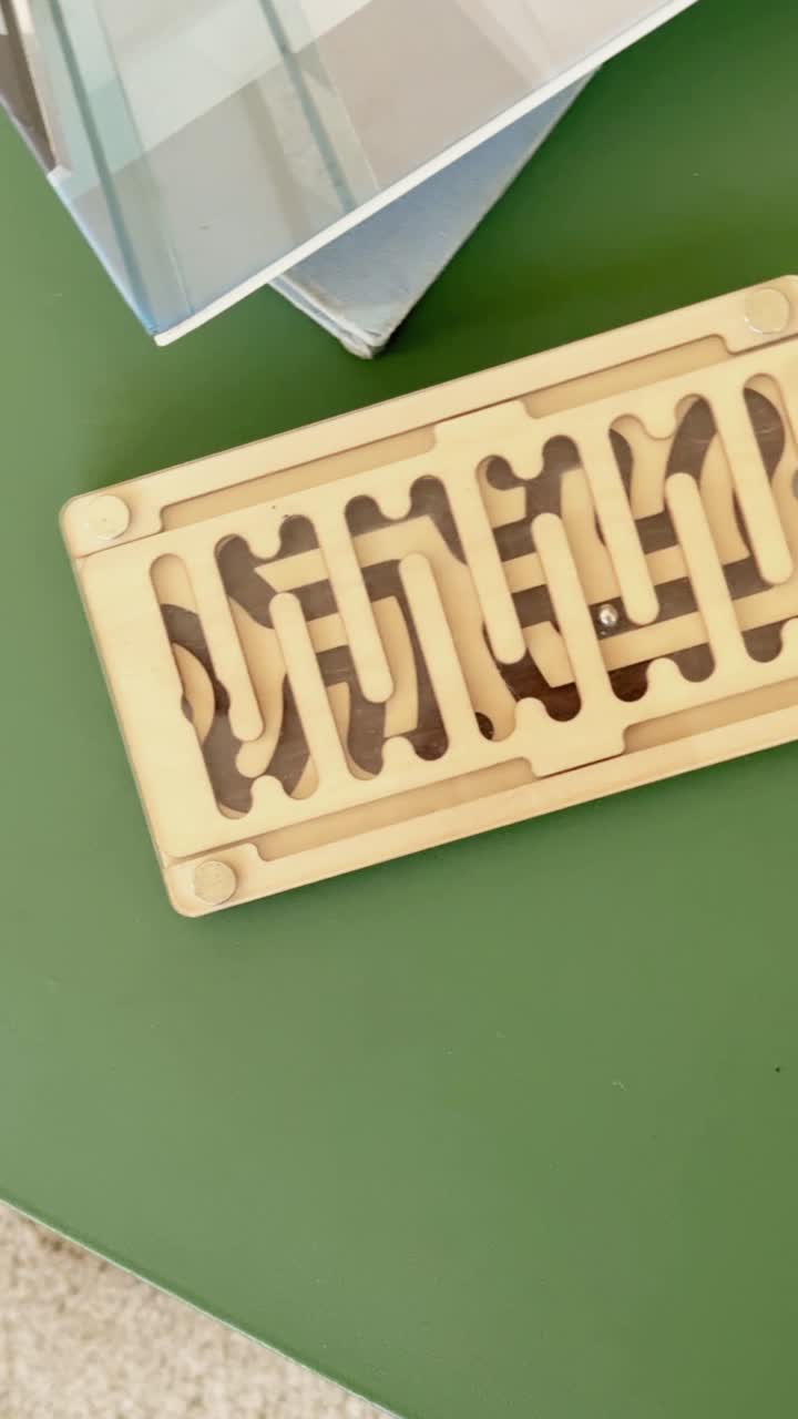 Close-up of a Wooden Maze Puzzle with a Rolling Metal Ball