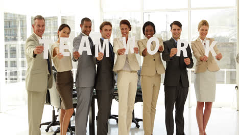 personas de negocios felices sosteniendo cartas deletreando trabajo en equipo