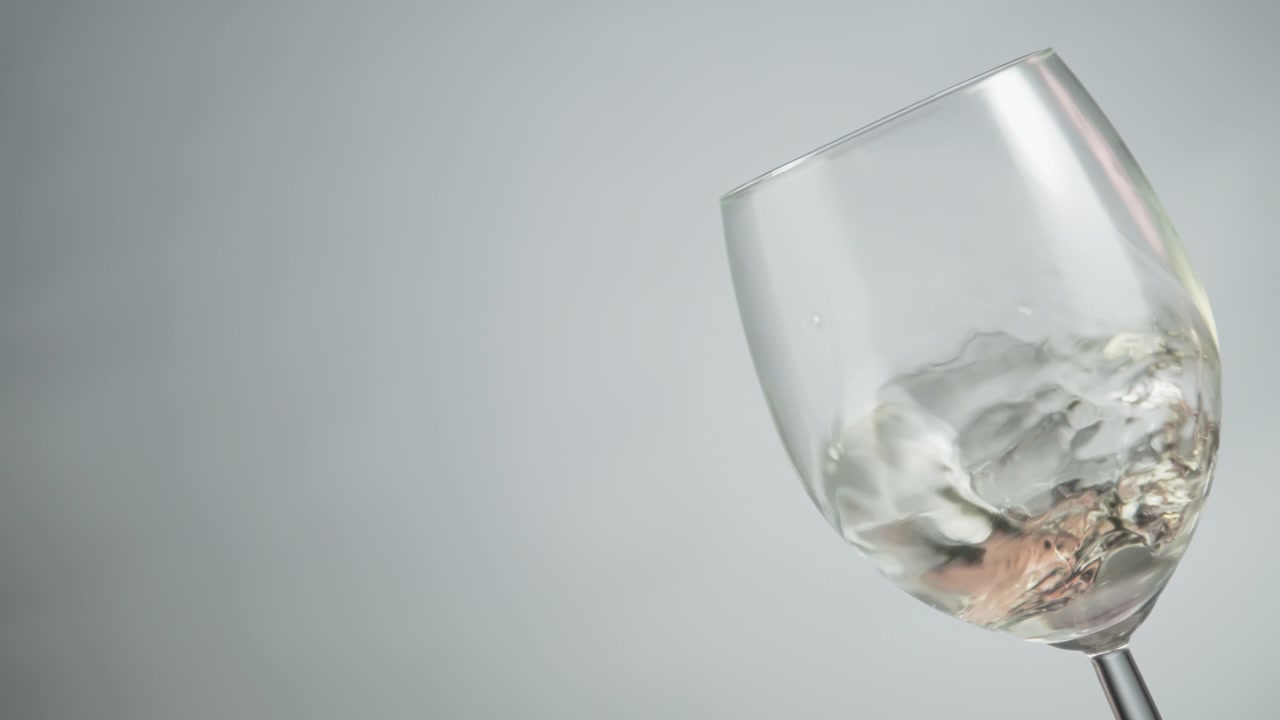 Vino bianco che volteggia all'interno di un calice da vino