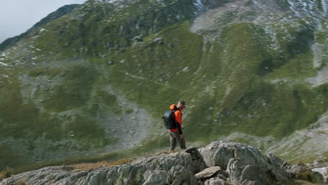 aerial view of a hiker with backpack walking on the peak of mountain