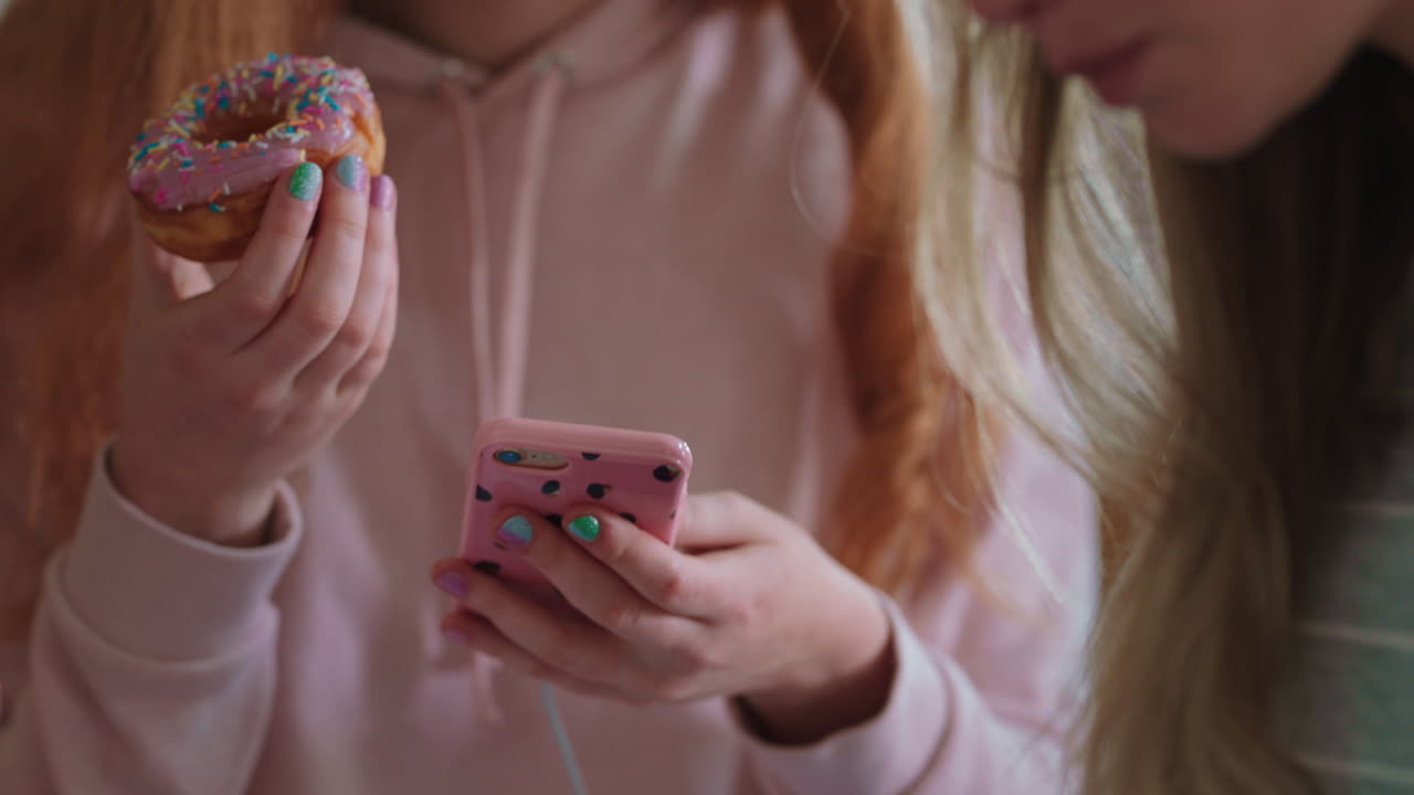 подростка, использующая смартфон, просматривающая социальные сети, отправляющая сообщения друзьям, гуляющая, едящая пончики