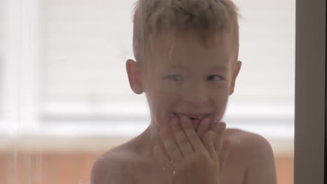 funny child fooling and laughing view through window