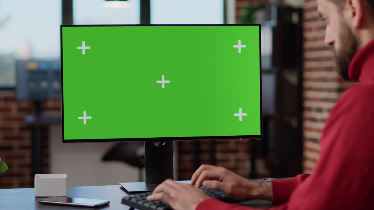 Executive manager looking at monitor with green screen