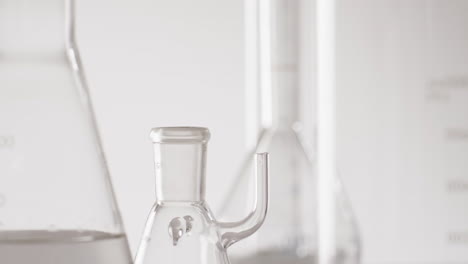 video of close up of glass laboratory beakers and dishes with copy space on white background