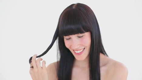 darkhaired woman holding a strand of her hair