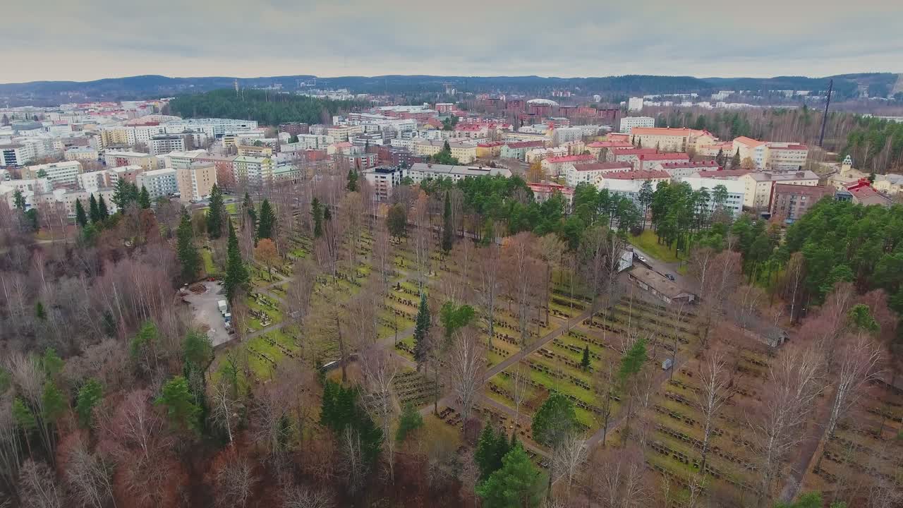 vista aérea de un cementerio con la ciudad al fondo en un día de otoño