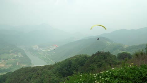paragliders take off one by one from the mountain on an extremely dusty day high air polution in danyang south korea