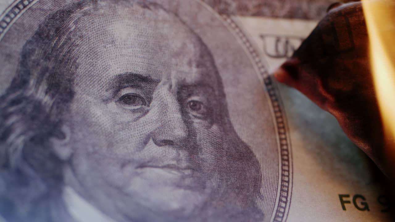el billete de cien dólares está en llamas.