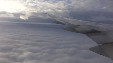mirando por la ventana de un avión a las nubes