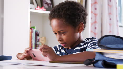 Niño-Sentado-En-El-Escritorio-En-El-Dormitorio-Jugando-En-El-Teléfono-Móvil