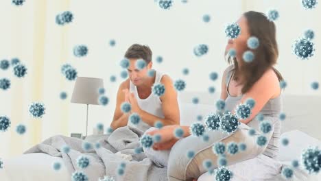 Digital-composite-video-of-Covid-19-cells-moving-against-couple-having-a-fight-in-bed-in-background