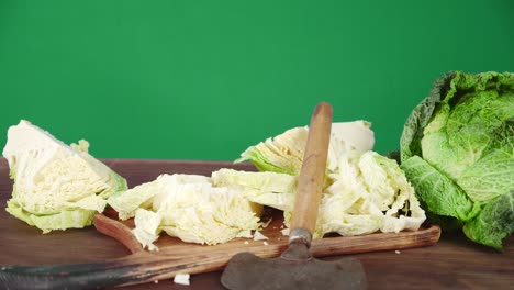 pieces of cabbage on a cutting board with slicer slowly rotate.