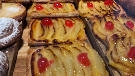 delicious fruit tarts with glaze and croissants on a wooden board