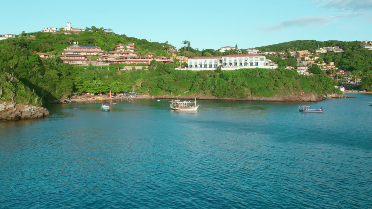 Aerial view Big Fishing Boat, Clean Waters of Joao Fernandinho beach B&uacute;zios, Jungle Hills Background with Resorts and Holiday Houses