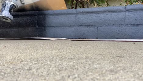 painter, painting brick wall with sprayer, in slow motion.