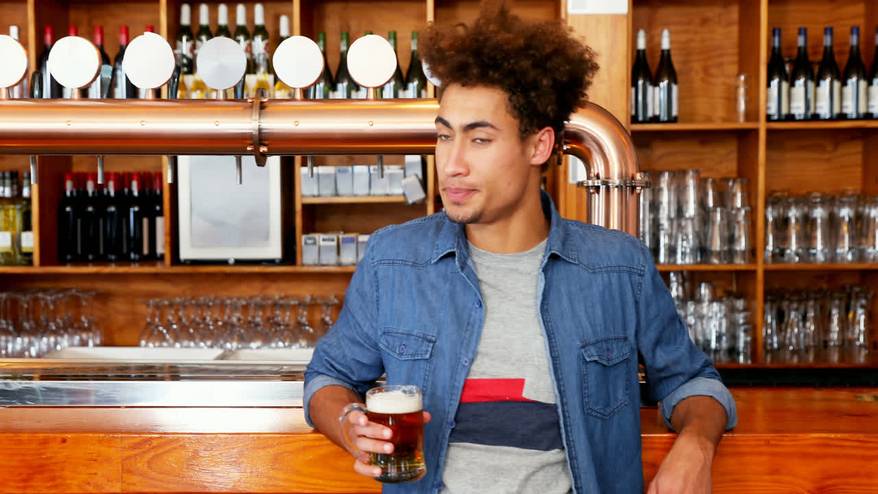 Uomo che beve una pinta di birra al bar 4k