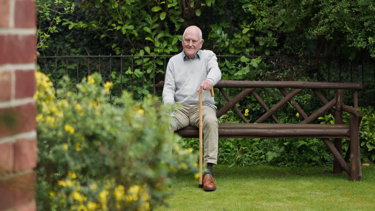 Elderly man relaxing on a bench in a garden